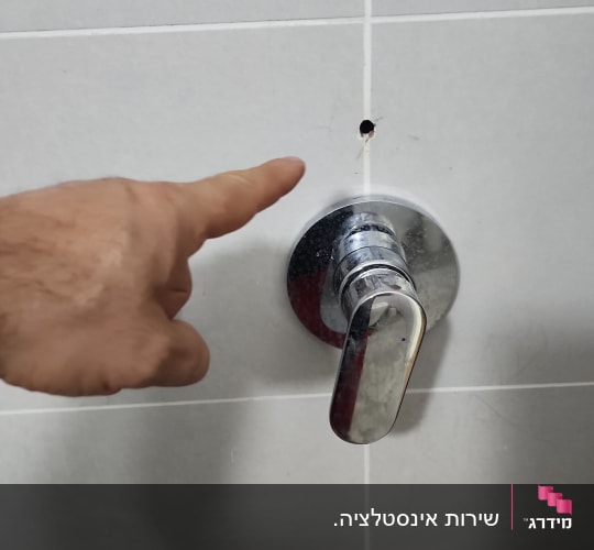 סוללת ברז כרום מותקנת על קיר אריחים בחדר רחצה